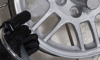 Alloy wheel being cleaned and finished by wet blasting