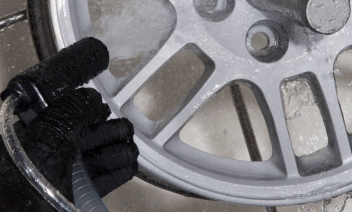 Alloy wheel being cleaned and finished by wet blasting